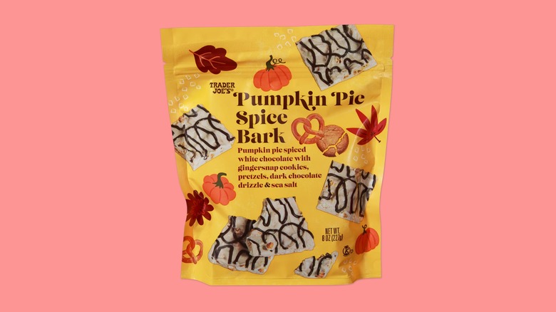 A bag of the Pumpkin Pie Spice Bark sold at Trader Joe's on a pink background.