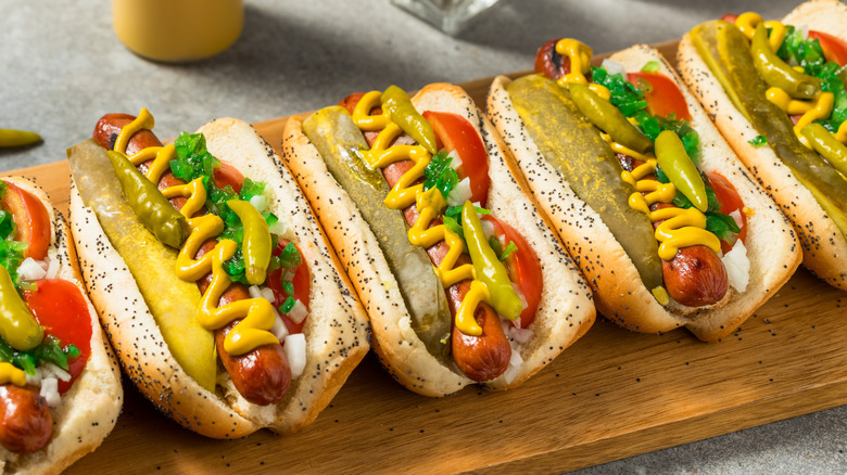 Chicago-style hot dogs with mustard, pickles, tomatoes, and sport peppers