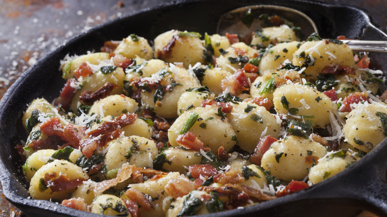 A cast iron skillet of tomato and basil gnocchi pasta