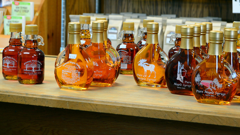 Different grades of maple syrup in various shaped glass bottles with little handles