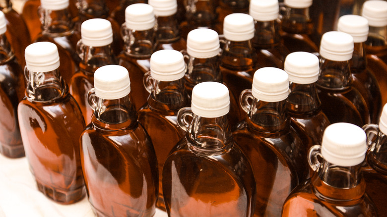 Rows of maple syrup in glass bottles with a tiny handle