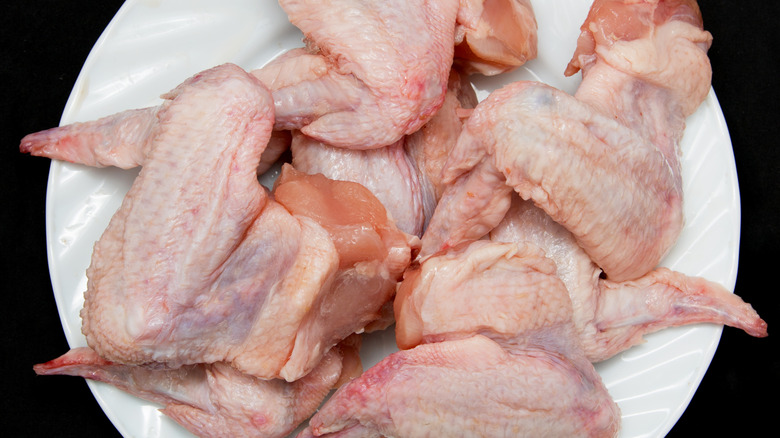 raw chicken wings on a white plate