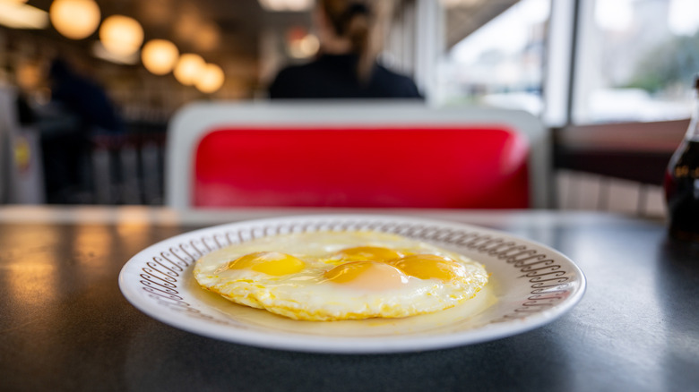 Plate of sunny side-up eggs at a Waffle House booth table