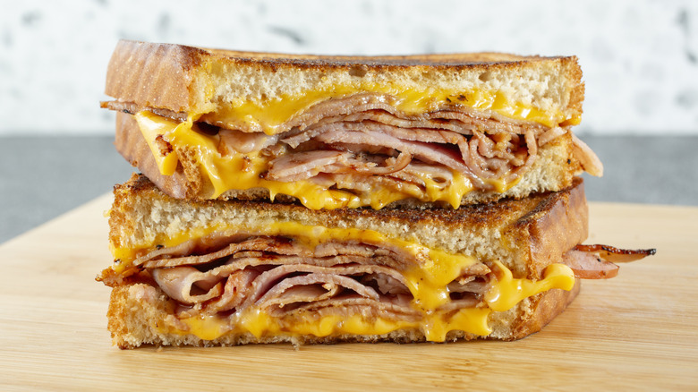Grilled ham and cheese sandwich on wooden cutting board