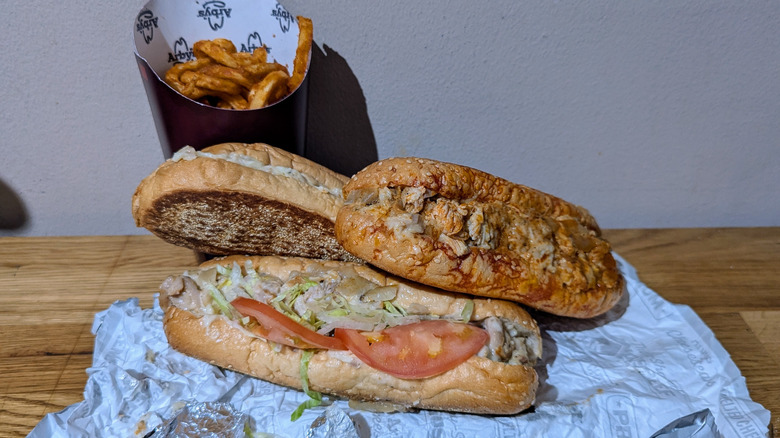 Three new Chicken Cheesesteaks from Arby's with curly fries.