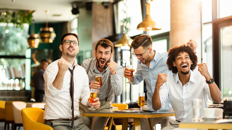 A group of guys at a restaurant watching the game.