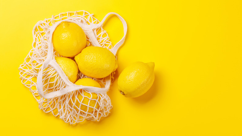 Bag of lemons on a yellow background