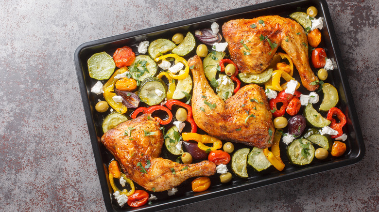A sheet pan topped with chicken, feta, and zucchini
