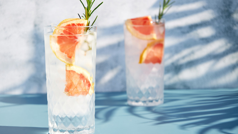 Cocktail in a highball glass with grapefruit and rosemary garnish