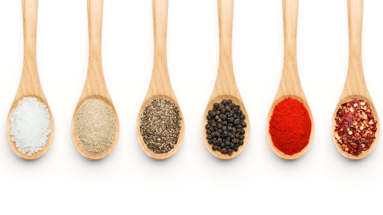 Several wood spoons holding different spices