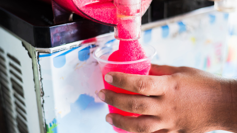 Hand filling up cup with slushy drink