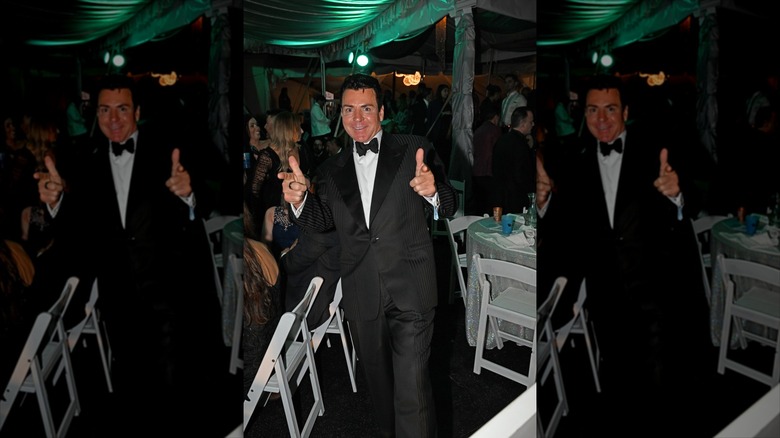 John Schnatter in a suit giving a thumbs up
