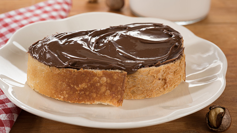 A piece of bread that's covered with Nutella.