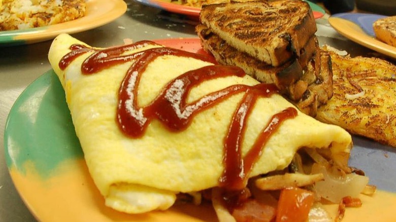 Omelet with side of toast from Cosmic Omelet on a multi-colored plate