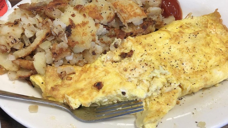 Omelet with side of hash browns from Libby's Restaurant on a white platter