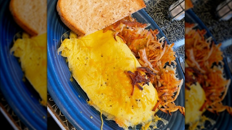 Omelette with side of toast and hash browns from Good Morning Mama's on a blue plate