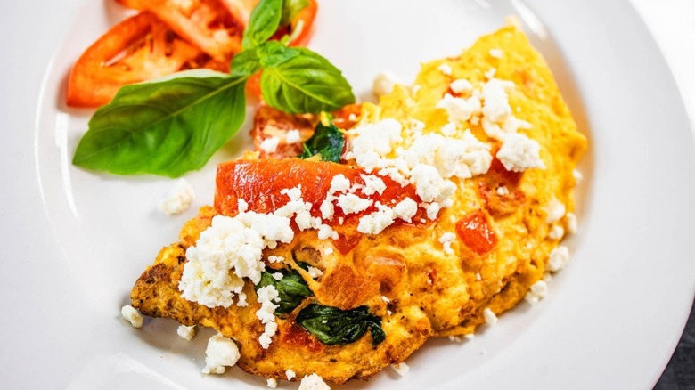 Veggie omelet from Highland Morning with fresh sliced tomato on the side on a white plate