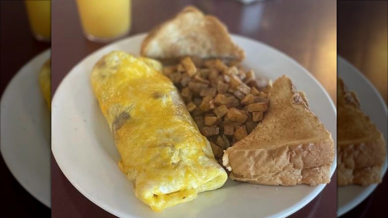 Meat Lovers Omelet with toast and potatoes from Port City Cafe on a white plate
