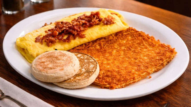 Meat Lovers Omelette with side of hash browns and English muffin from Billy Gail's on a white platter