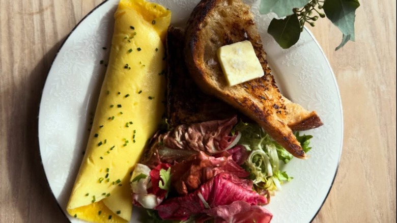 The French Omelette with country toast and local salad from Mother on a white plate