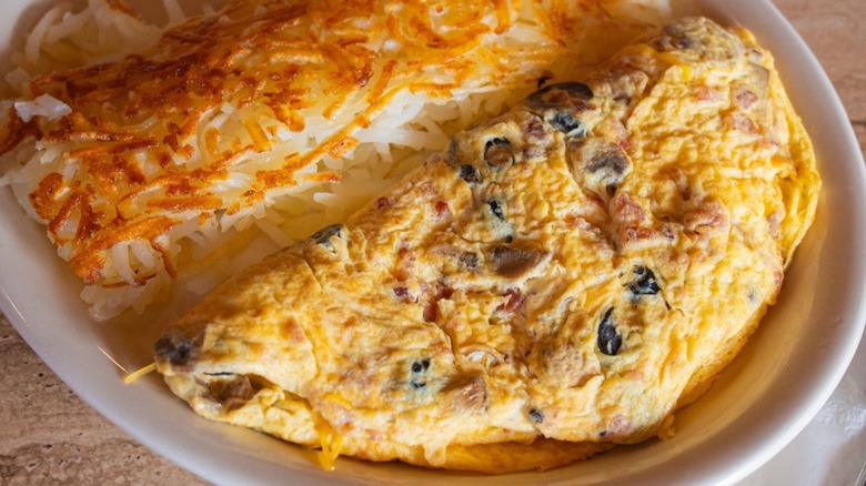 Omelet with side of hash browns from Sybil's Omelettes on a white plate