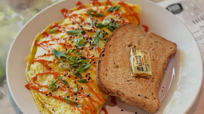 Omelet with side of toast and pat of butter from Perch on a white plate