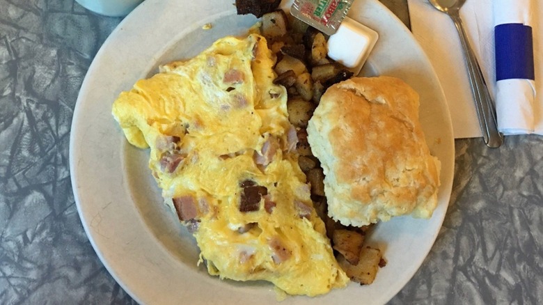 Western Omelette with potatoes and a biscuit from Henry's Diner on a white plate