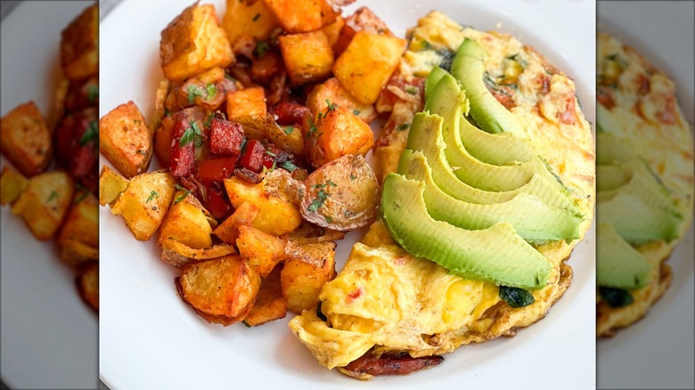 Omelet topped with avocado with potatoes from The Boathouse on a white plate