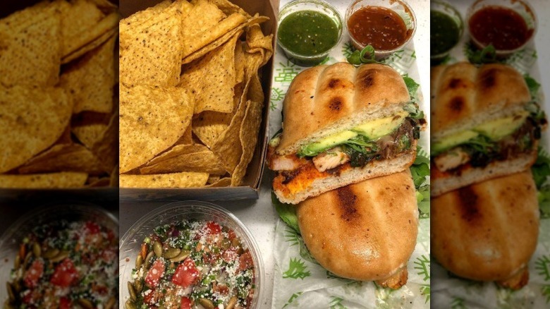 chipotle chicken torta with a side of tortilla chips, salsa verde, salsa roja, and a mix of pumpkin seeds, tomatoes, onions, and other vegetables