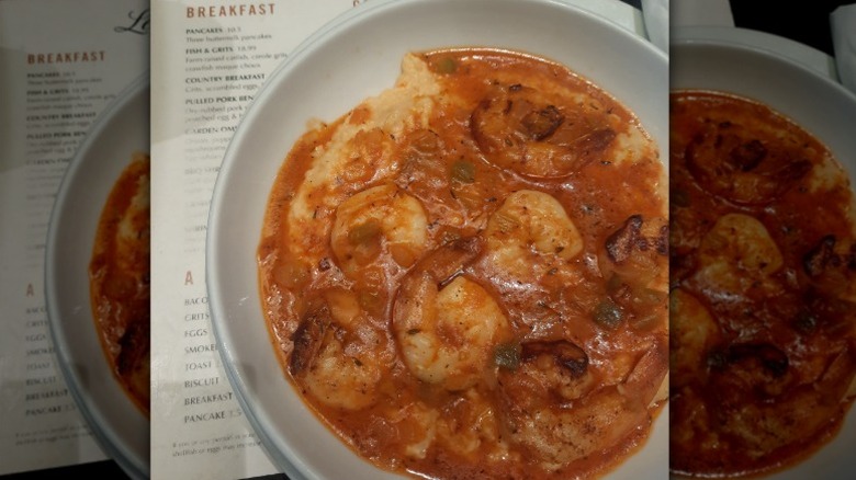 a bowl of shrimp and grits sits on top of a menu at Leah's Kitchen