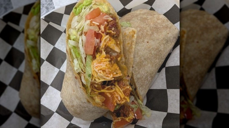 chicken bacon wrap with lettuce, tomato, cheese, and buffalo sauce on checkered paper