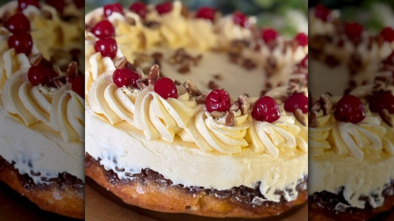 a cheesecake topped with maraschino cherries and walnuts