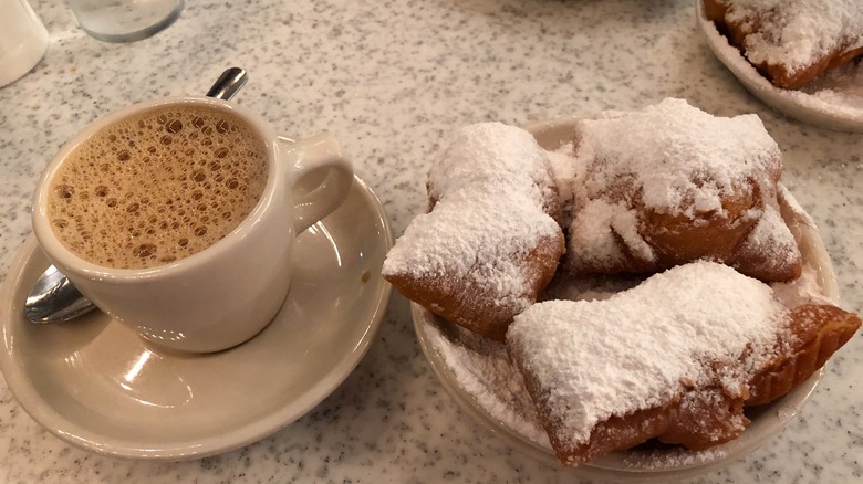 A plate of beignets and a cup from Cafe du Monde