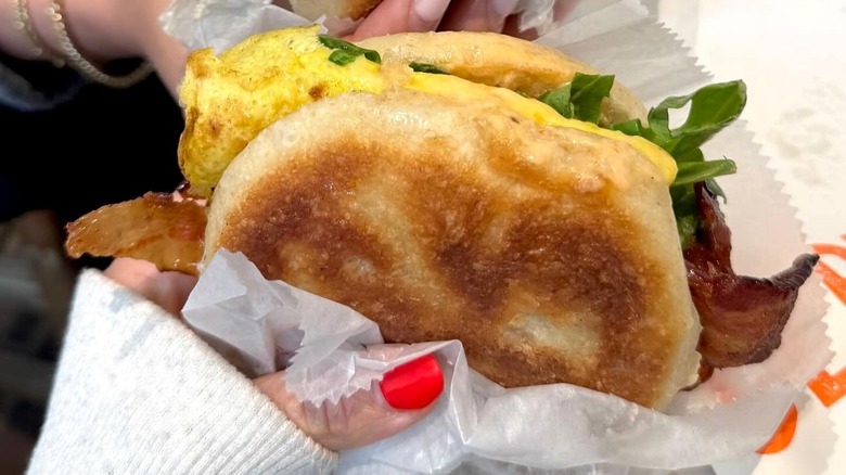 hand holding breakfast sandwich