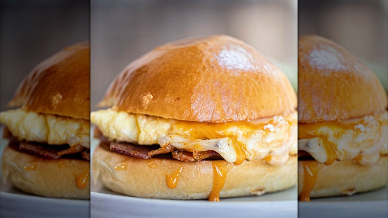Breakfast sandwich with yolk oozing over the side of bread