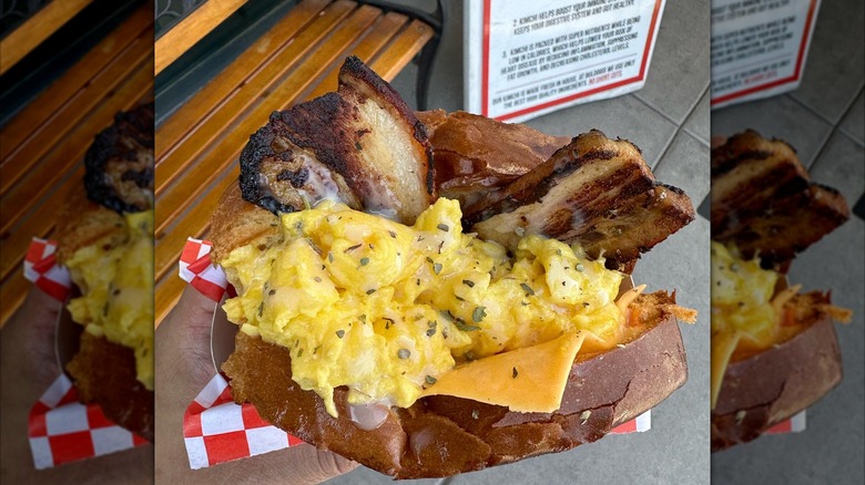A huge breakfast sandwich with egg and thick bacon