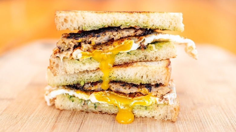 Egg oozes over the bread on a breakfast sandwich