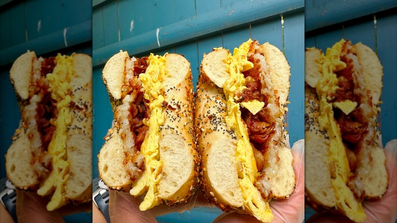 A big bagel sandwich with eggs and bacon