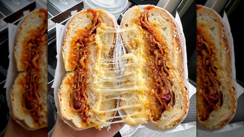 Cheese oozes out of a breakfast sandwich full of meat