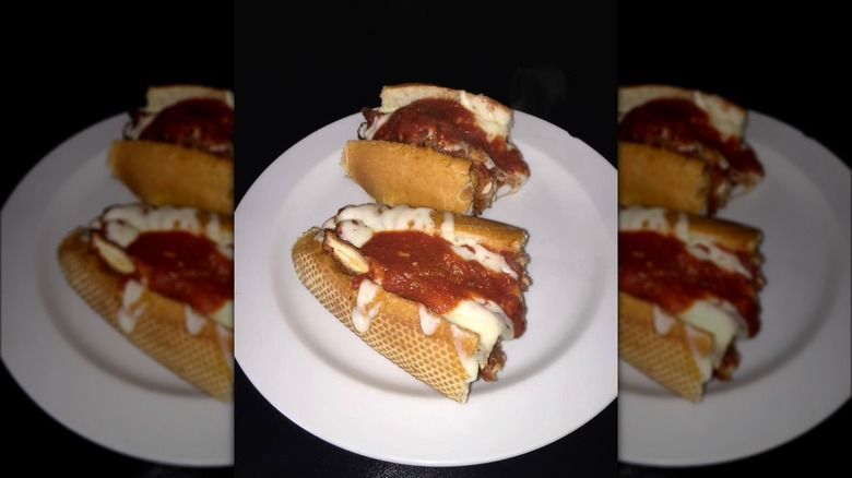 Two halves of chicken Parmesan sandwich on plate