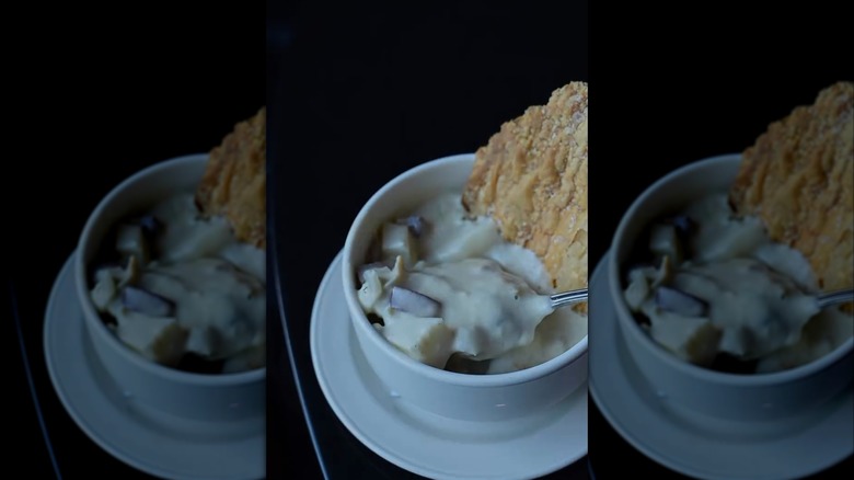 Row 34 clam chowder close up in a mug with a fancy cracker