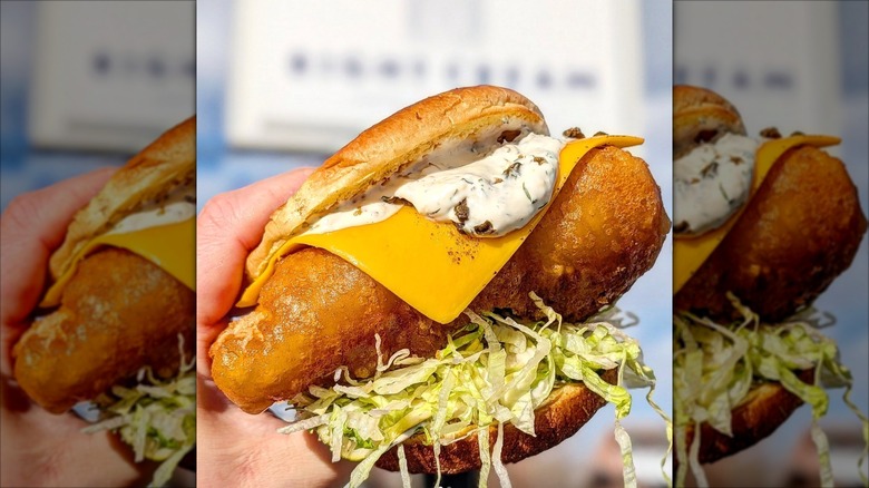 Hand holding a Right Cream Fried Fish Sandwich