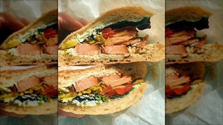 Person holding a Northern Waters Smokehaus Cajun Finn sandwich