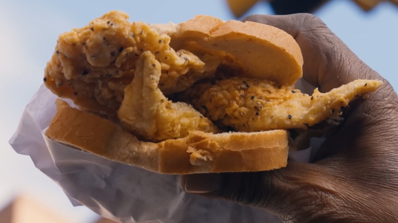 Person holding a Famous Fish Market Fried Whiting Sandwich