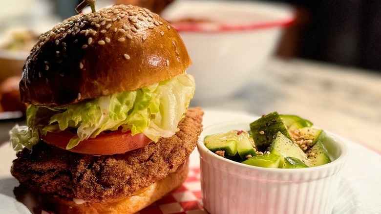 Leon´s Oyster Shop Crispy Catfish sandwich with a cucumber salad on a white plate