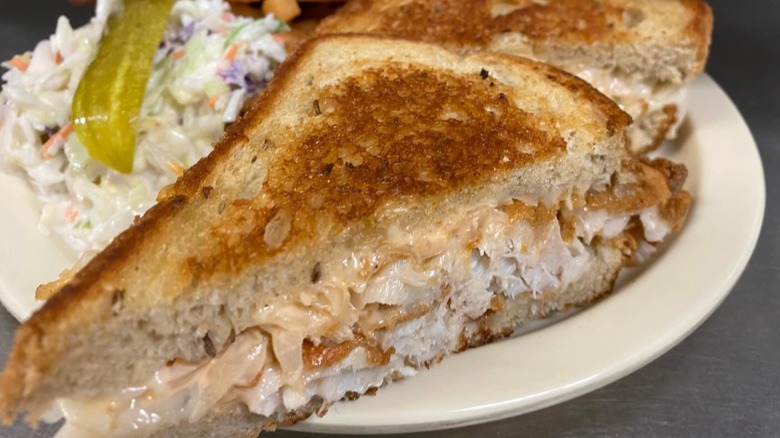 Beach Pub Rockfish Reuben Sandwich with coleslaw and a pickle slice
