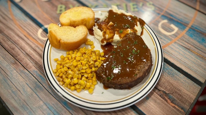 Meatloaf at francesca by katie's with sides of mashed potatoes and gravy, corn and bread