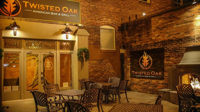 Twisted Oak American Bar & Grill outdoor dining area with brick and fireplace at night