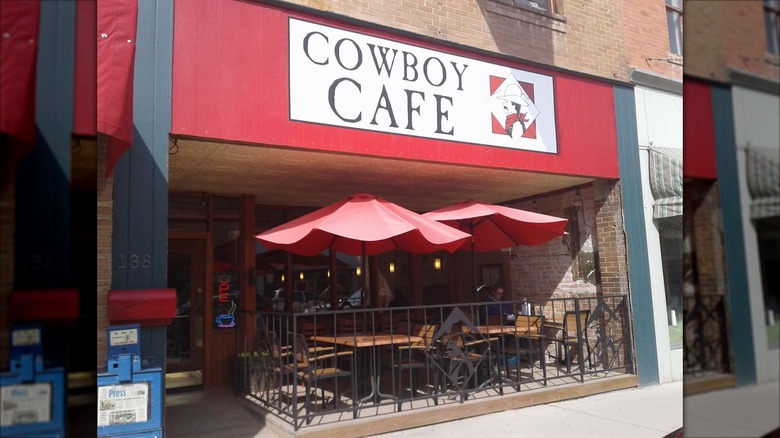 Cowboy Cafe exterior with small outdoor patio and red parasols