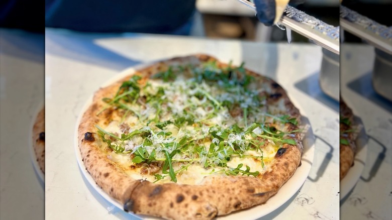Parmesan shredded over greens pizza